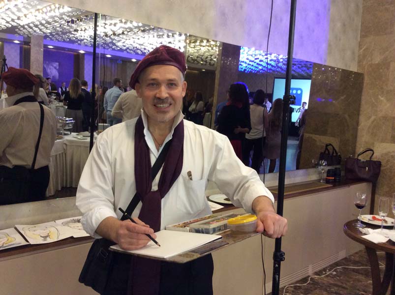 Художник улыбается и держит мольберт шаржист Михаил Шабалин Мишель Минск